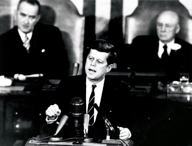 Präsident John F. Kennedy bei seiner historischen Rede am 25. Mai 1961, in der er vor dem Kongress ankündigte, die Vereinigten Staaten werden „einen Menschen auf den Mond und wieder sicher zurück zur Erde bringen.“ Die Rede basiert auf einem Momorandum über Perspektiven der zivilen Raumfahrt, das Wernher von Braun knapp ein Monat zuvor an den Präsidenten gerichtet hatte.